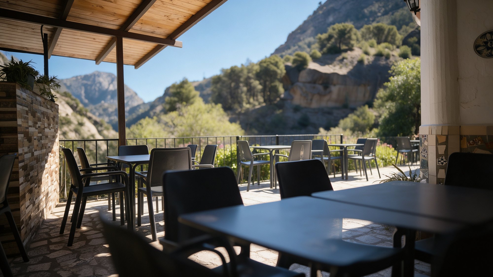 Terraza cubierta del restaurante La Ermita con la garganta y mesas servidas